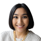 A woman with a short haircut and a gold necklace smiling at the camera.